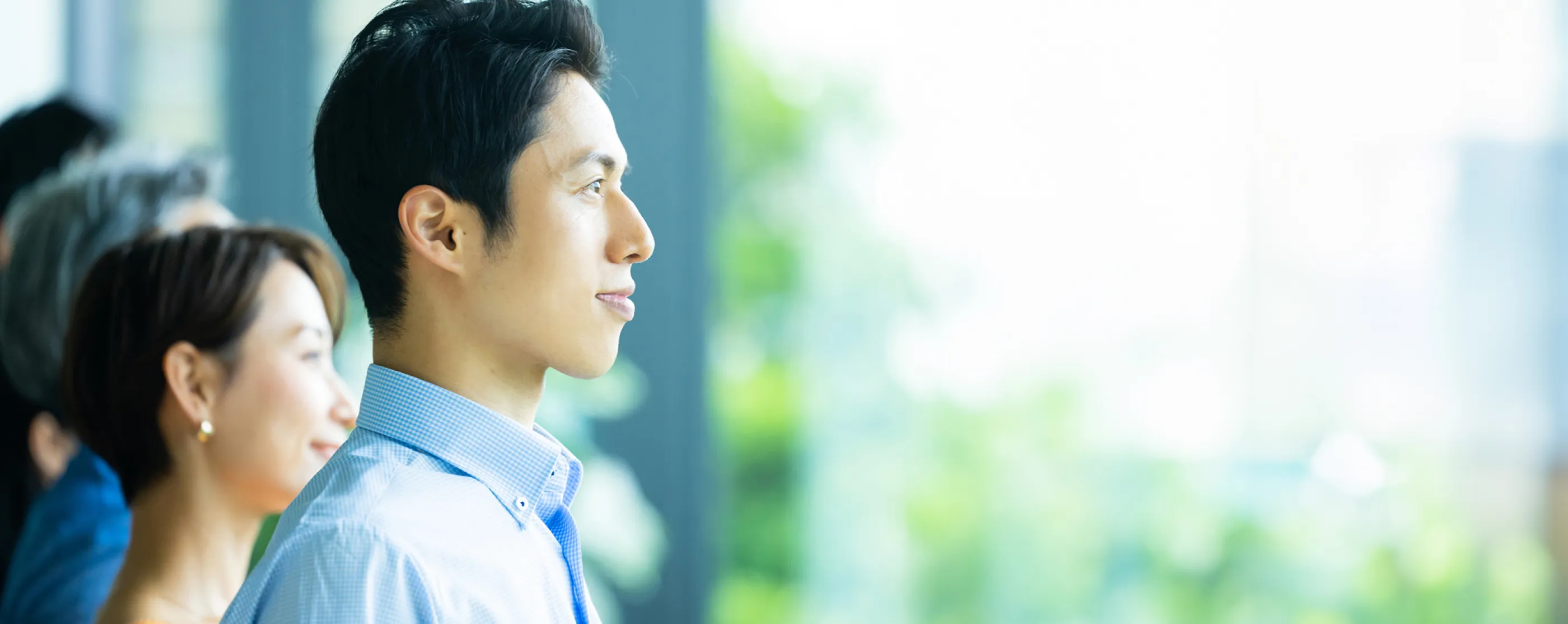 数人の社員が並んで一点を見つめている様子