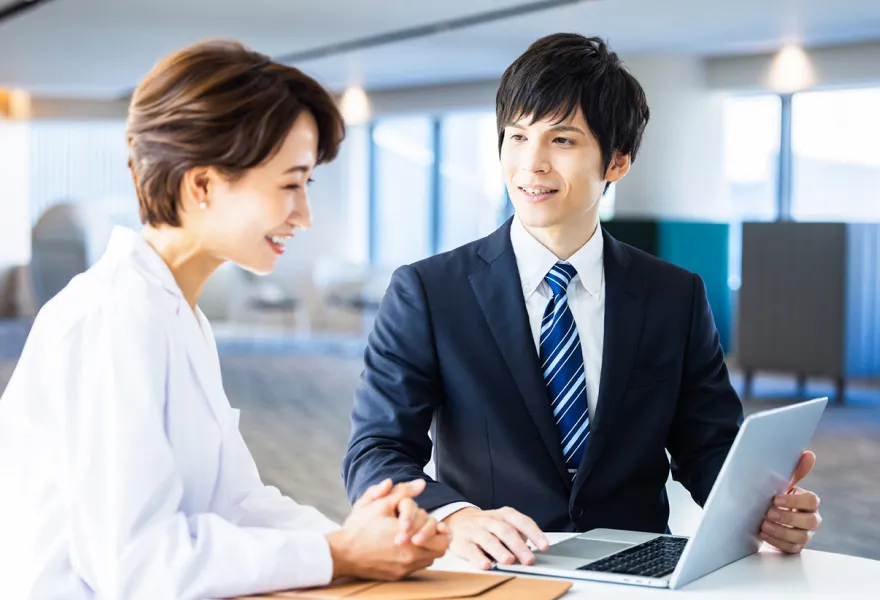 女性にパソコンを使って説明している様子