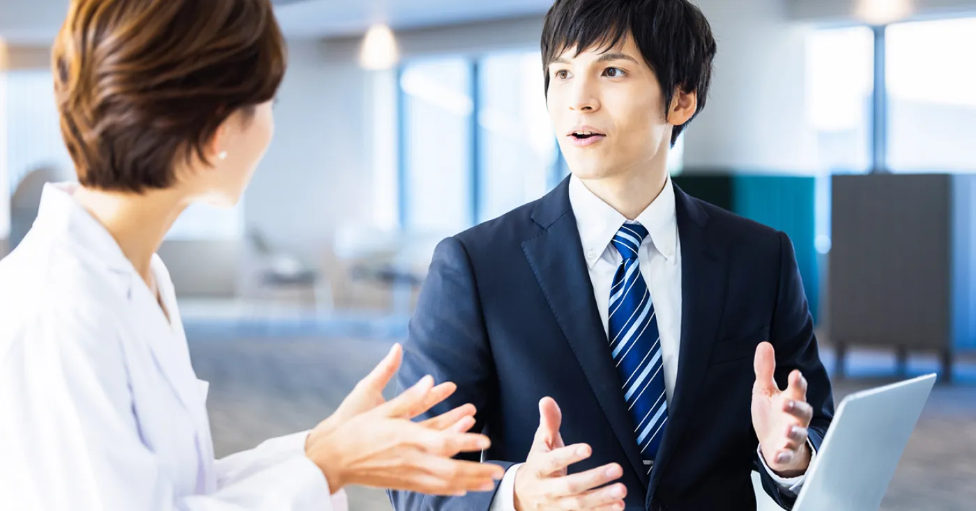 スーツ姿の男性スタッフが説明している写真